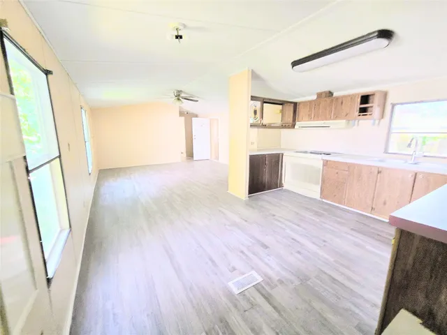 a view of a kitchen with wooden floors and wooden cabinets