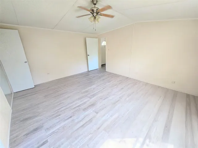 a view of a room with wooden floor and a ceiling fan