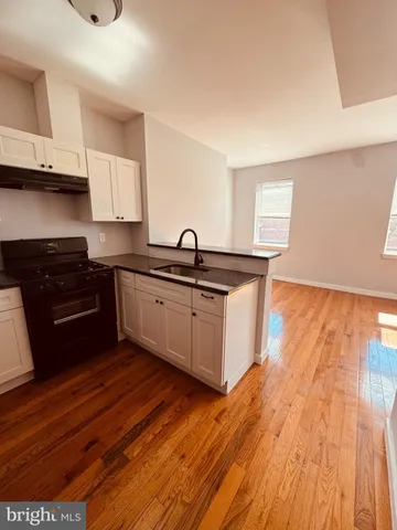 a kitchen with granite countertop a sink and cabinets