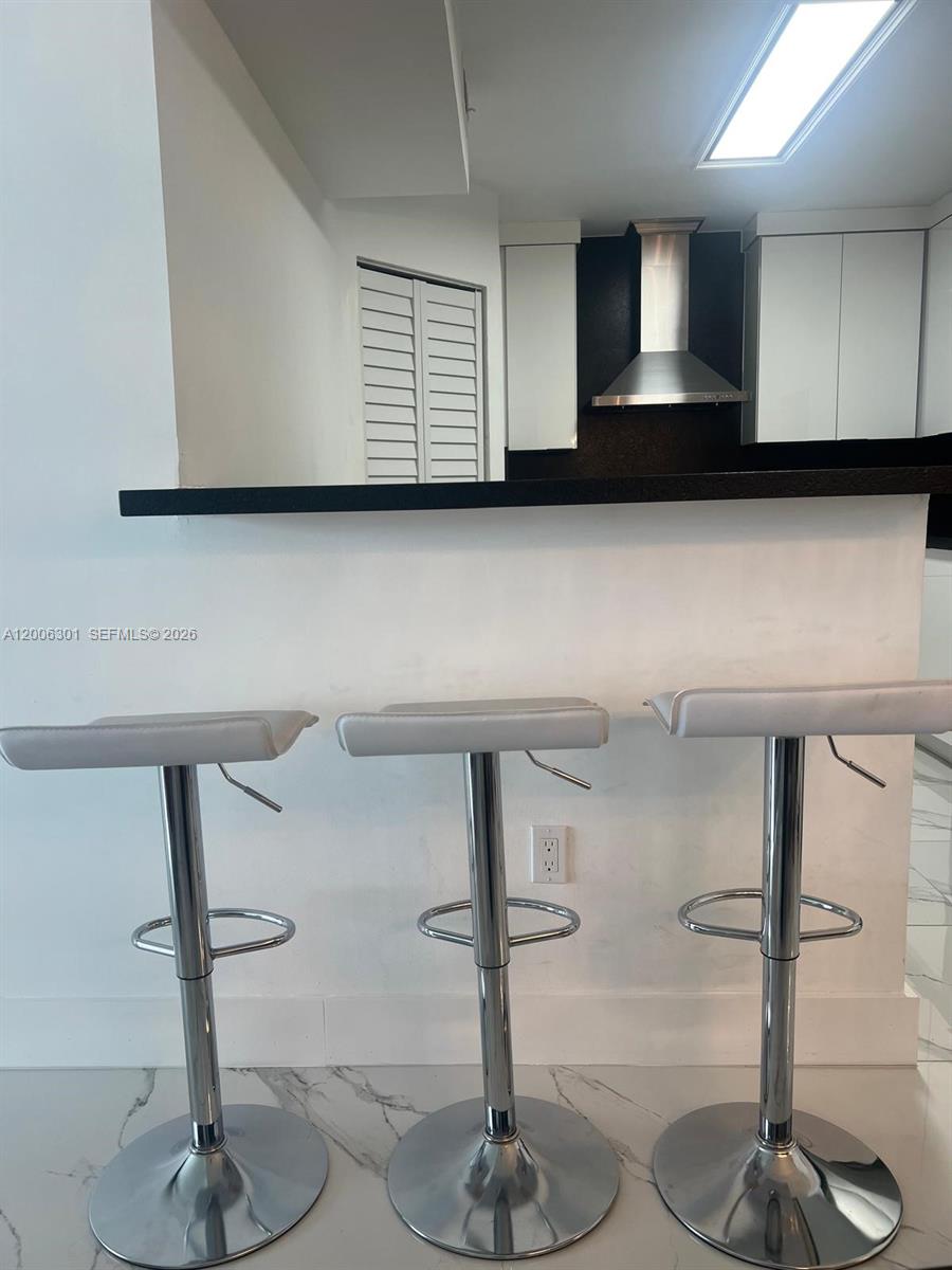 9273 Collins Avenue, Unit 606 Surfside, FL 33154 - Photo 12 of 25 a kitchen with sink and cabinets