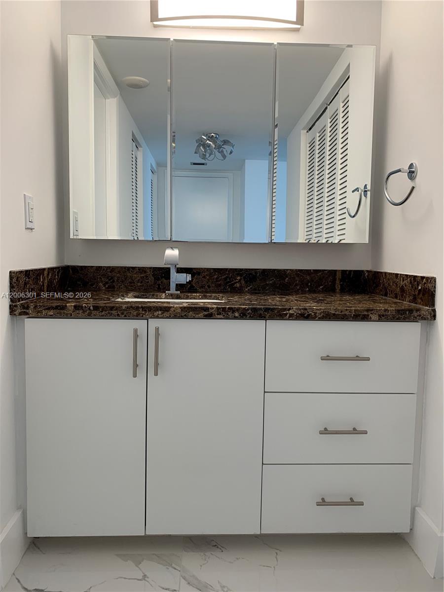 9273 Collins Avenue, Unit 606 Surfside, FL 33154 - Photo 14 of 25 a bathroom with a granite countertop sink and a mirror