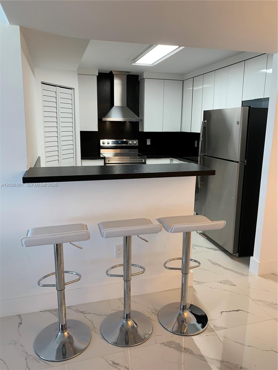 9273 Collins Avenue, Unit 606 Surfside, FL 33154 - Photo 22 of 25 a kitchen with a refrigerator and a sink
