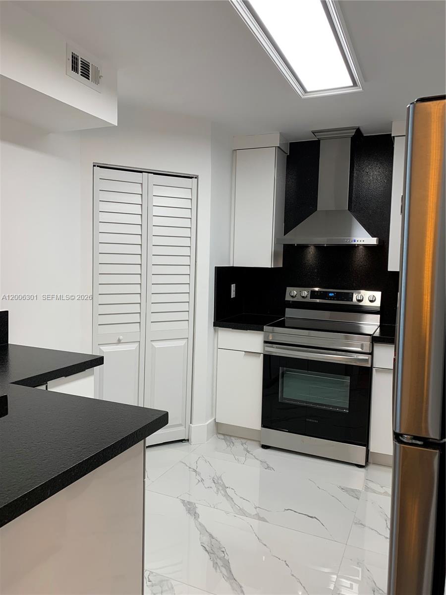 9273 Collins Avenue, Unit 606 Surfside, FL 33154 - Photo 7 of 25 a kitchen with a stove and a microwave