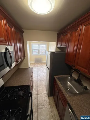 a kitchen with granite countertop a stove a sink and a microwave