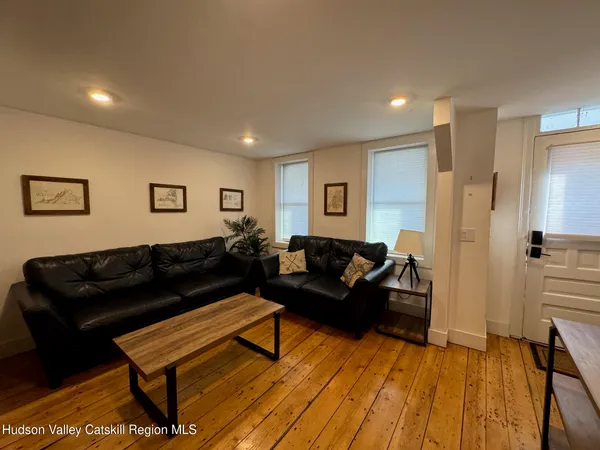 a living room with furniture and a wooden floor