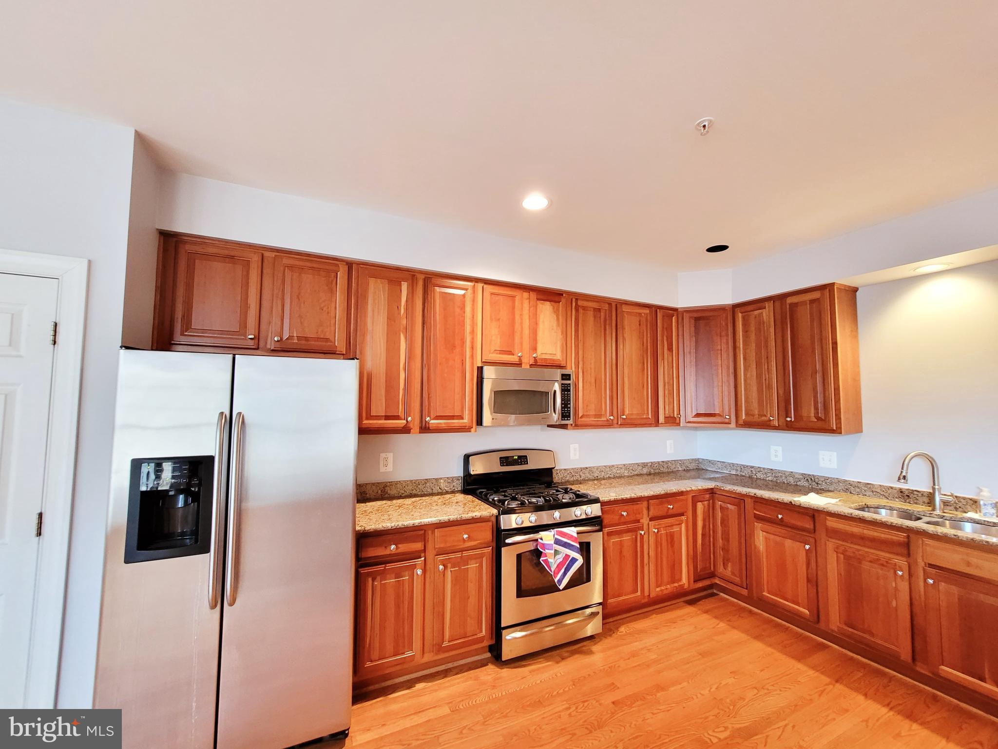 3960 Addison Woods Road Frederick, MD 21704 - Photo 8 of 19 a kitchen with granite countertop a refrigerator stove top oven and sink
