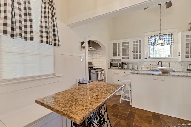 a kitchen with a table chairs cabinets and window