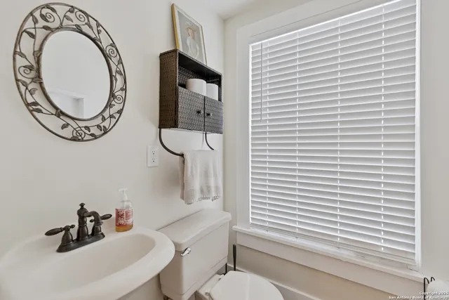 a bathroom with a toilet a sink and a mirror