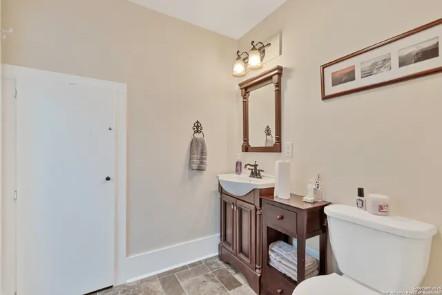 a bathroom with a toilet a sink and mirror