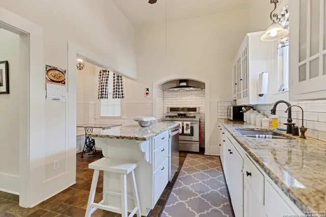 a kitchen with stainless steel appliances granite countertop a sink stove and cabinets