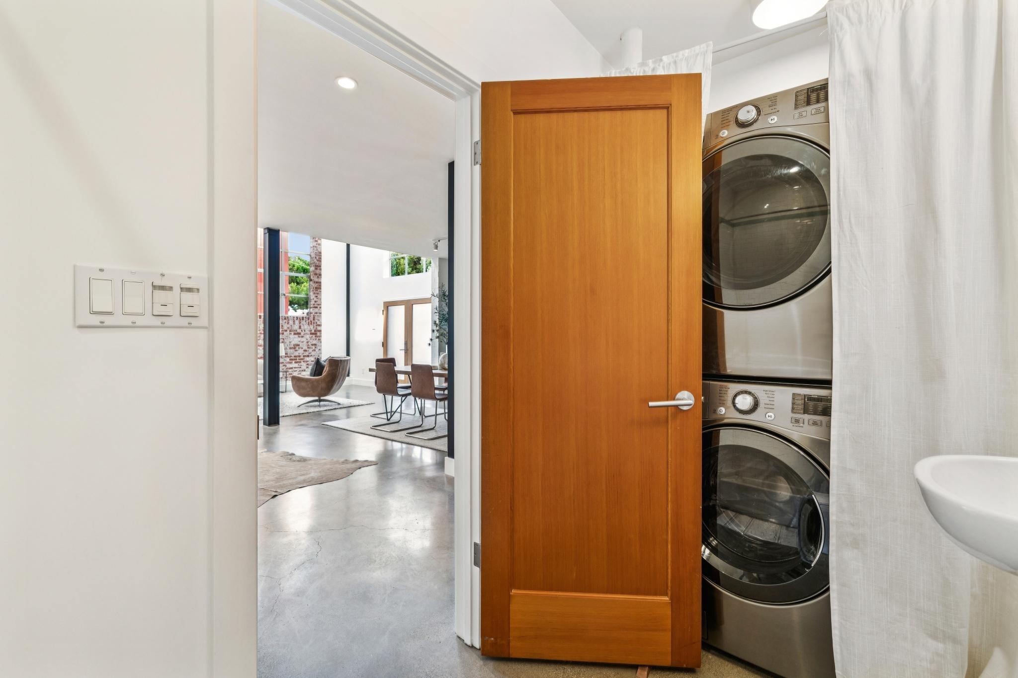 829 21st Street, Unit 3 Oakland, CA 94607 - Photo 19 of 47 Laundry area with stacked washer and clothes dryer, concrete flooring, recessed lighting, and floor to ceiling windows