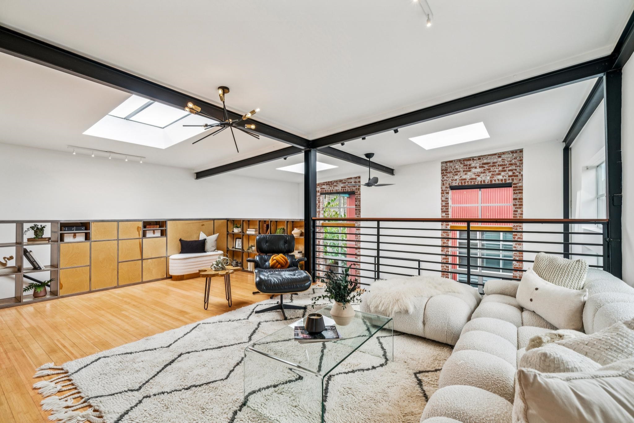 829 21st Street, Unit 3 Oakland, CA 94607 - Photo 24 of 47 Living room featuring rail lighting, a skylight, wood finished floors, and beam ceiling