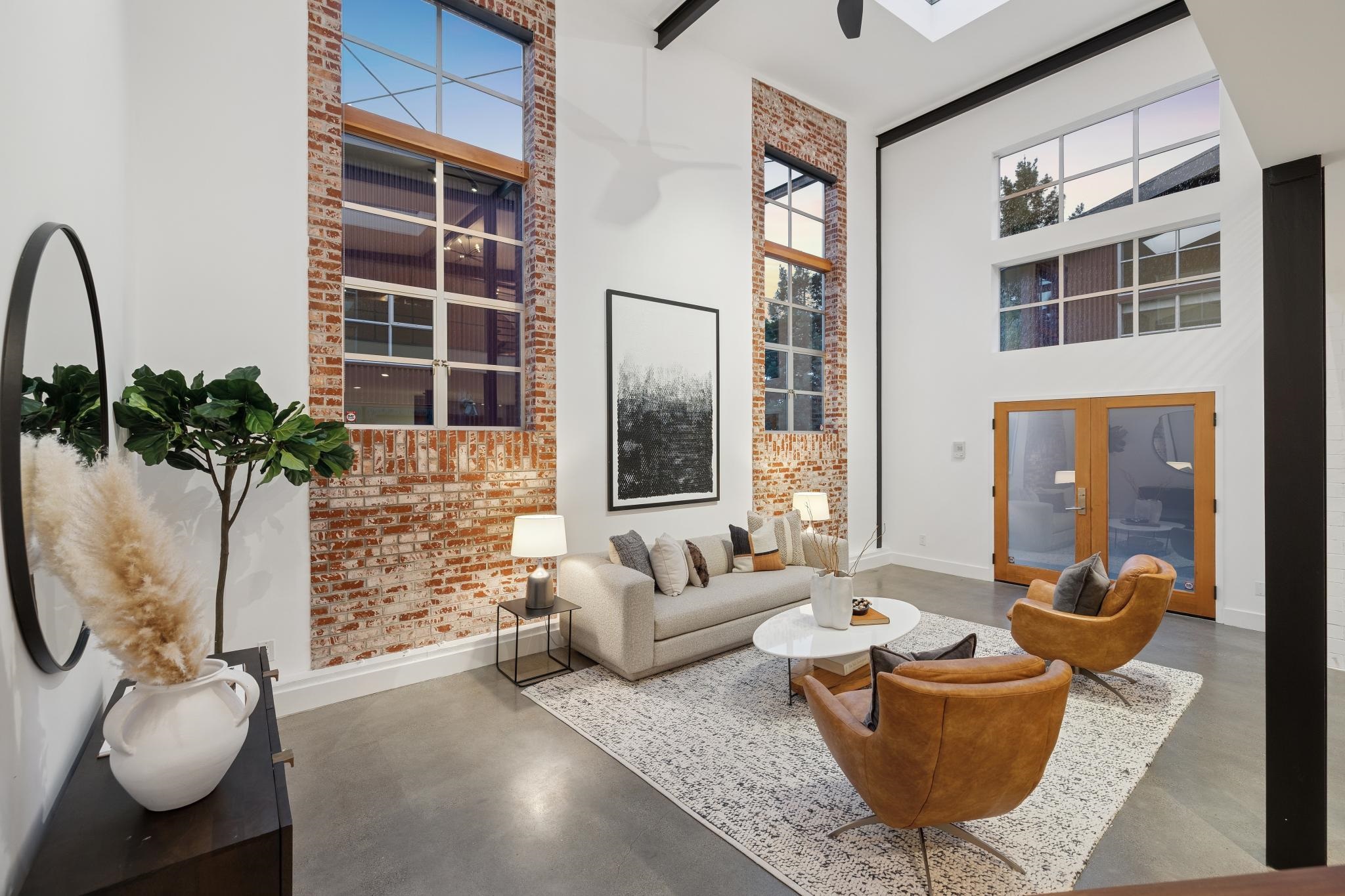 829 21st Street, Unit 3 Oakland, CA 94607 - Photo 37 of 47 Living room featuring a high ceiling, brick wall, finished concrete floors, and french doors