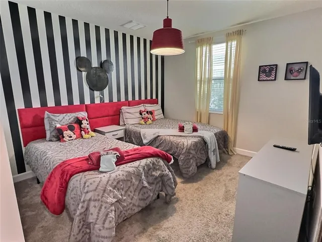 a bedroom with two beds and a chandelier