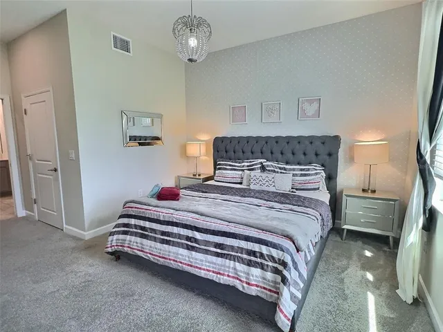 a bedroom with a bed and a chandelier