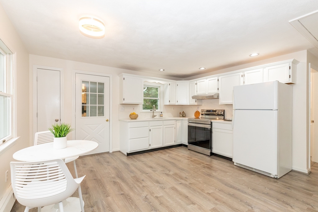 5 Ellen Road Burlington, MA 01803 - Photo 25 of 39 a kitchen with a refrigerator a stove a sink dishwasher with a dining table and chairs