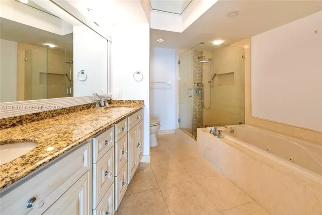 a spacious bathroom with a granite countertop tub sink and mirror