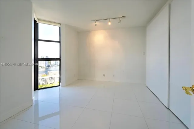 an empty room with windows and cabinet
