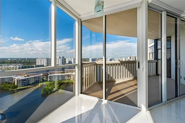 a city view from a balcony with a floor to ceiling window