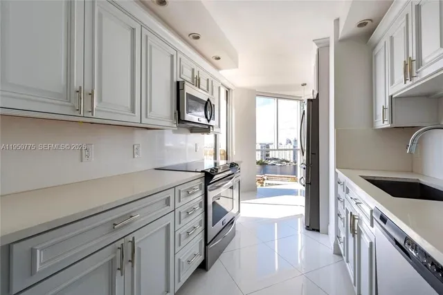 a kitchen with stainless steel appliances granite countertop a refrigerator and a stove