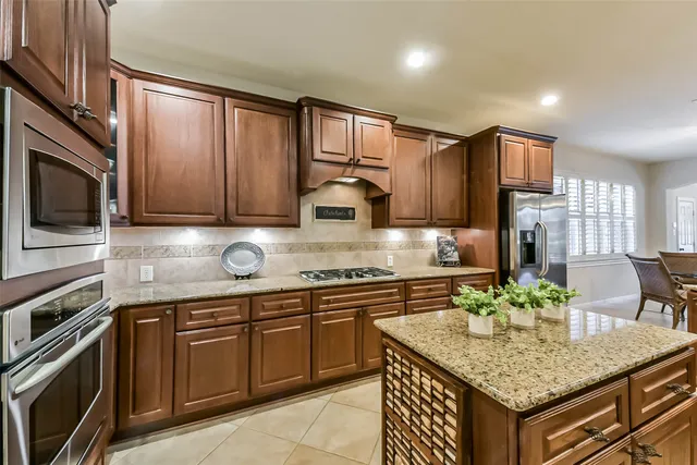 a kitchen with stainless steel appliances granite countertop a sink stove and microwave