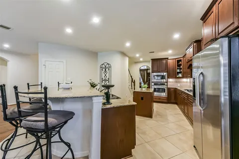 a kitchen with cabinets and chairs