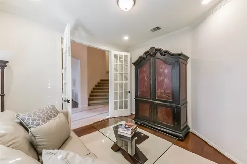 a living room with furniture a wooden floor and a ceiling fan