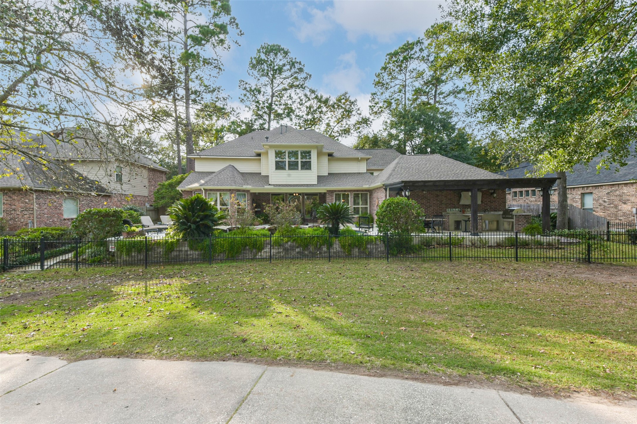 25295 Bull Ridge Drive Porter, TX 77365 - Photo 46 of 50 Rear elevation showcasing the covered patio, outdoor kitchen, pool area, and golf course backdrop.