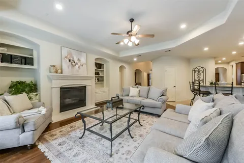 a living room with furniture a fireplace and a ceiling fan