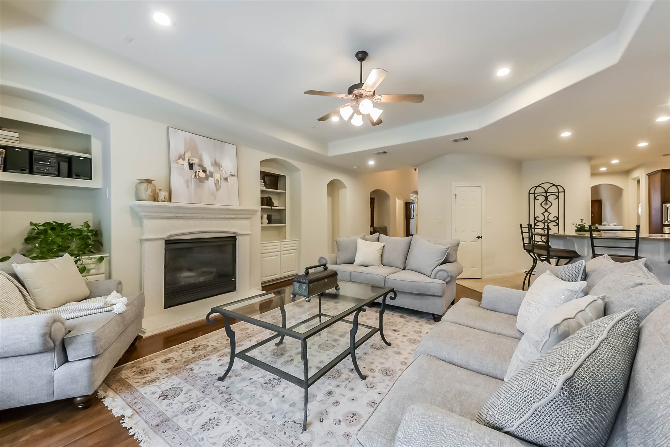 25295 Bull Ridge Drive Porter, TX 77365 - Photo 10 of 50 Bright and open living room with wall of windows, gas fireplace, built-ins, and tray ceiling