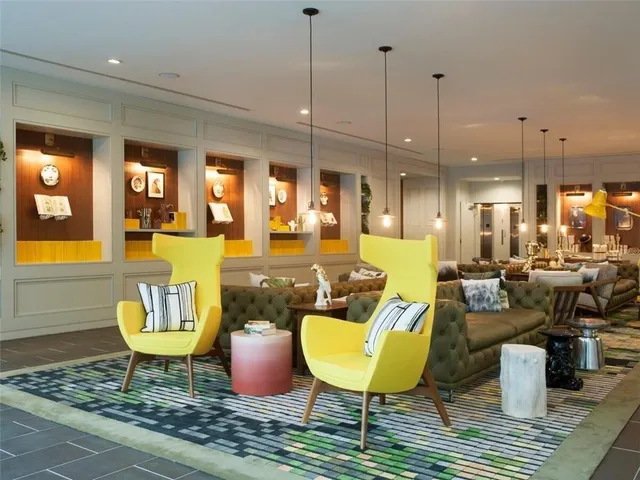 a living room with furniture kitchen view and a large window