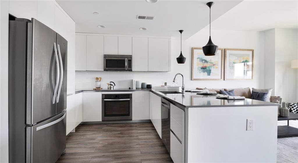 207 13th Street Northeast, Unit S2 Atlanta, GA 30309 - Photo 34 of 46 a kitchen with stainless steel appliances granite countertop a sink stove a refrigerator and a oven with wooden floor