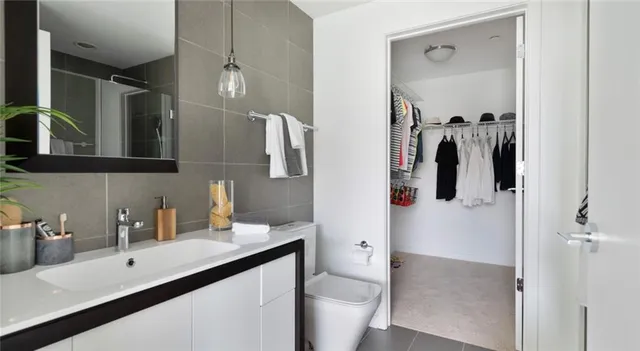 a kitchen with stainless steel appliances a refrigerator a stove a sink dishwasher and white cabinets with wooden floor