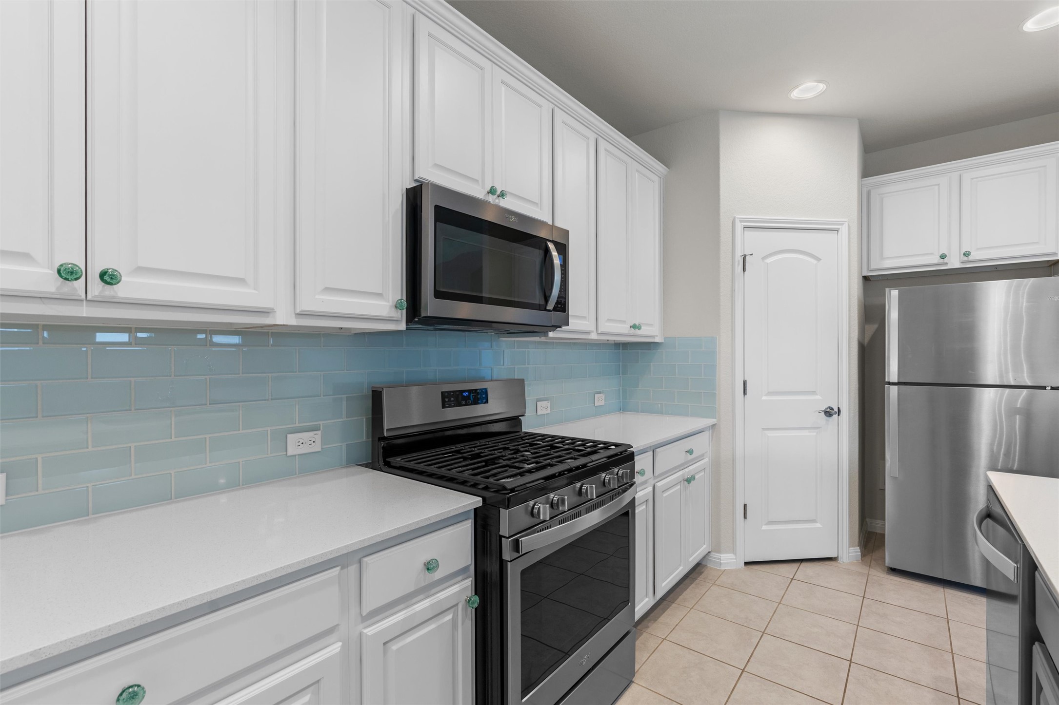 108 Calhoun Lane Georgetown, TX 78633 - Photo 13 of 32 a kitchen with white cabinets and white appliances