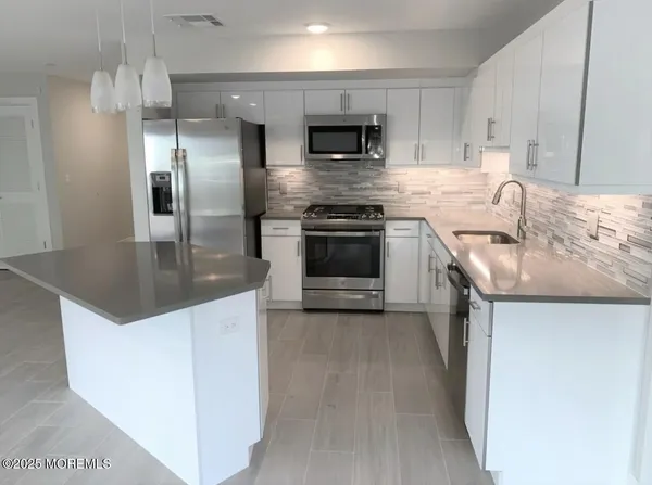 a kitchen with stainless steel appliances granite countertop a sink stove and refrigerator