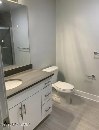 a bathroom with a granite countertop toilet and a sink