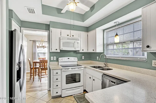 a kitchen with white cabinets and white appliances