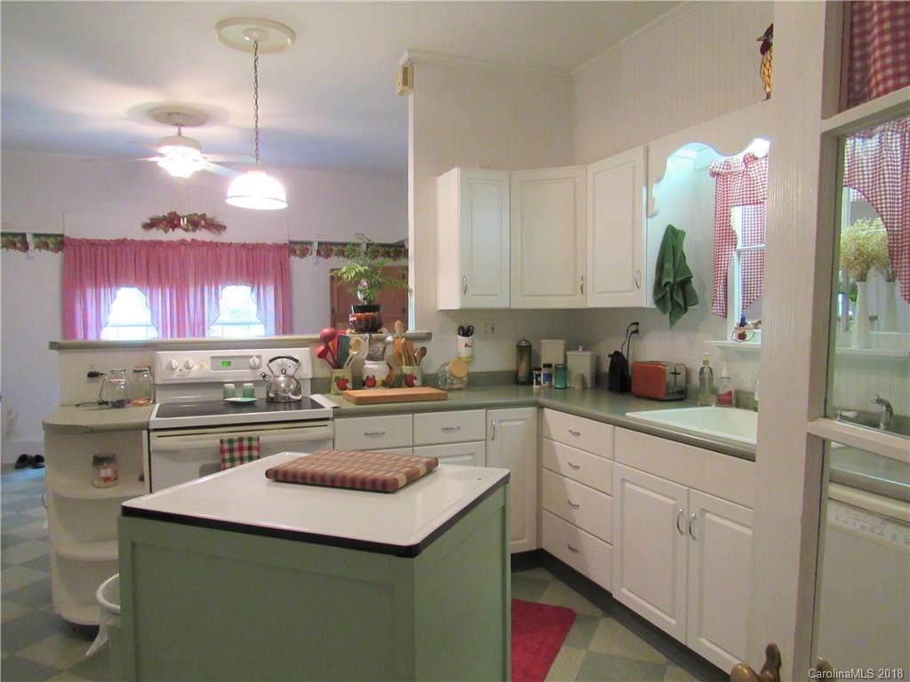 6737 Shiloh Unity Road Lancaster, SC 29720 - Photo 4 of 33 a kitchen with a sink dishwasher a stove a microwave oven and a dining table with wooden floor