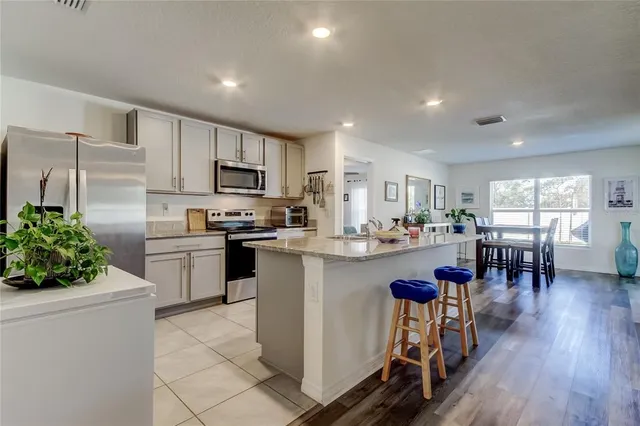 a kitchen with white cabinets and appliances