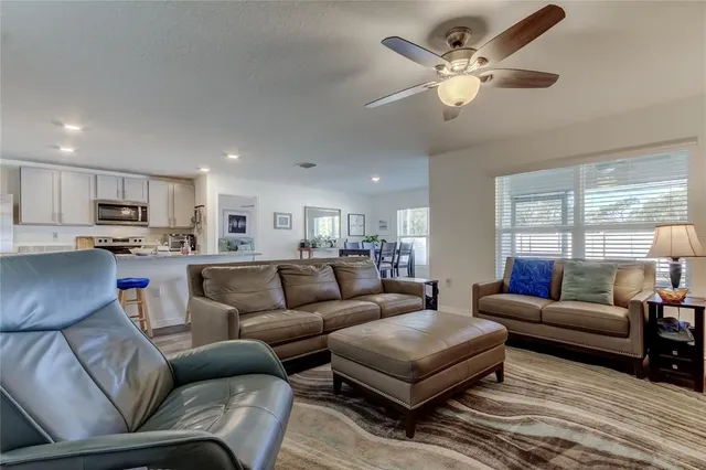 a living room with furniture a ceiling fan and a rug