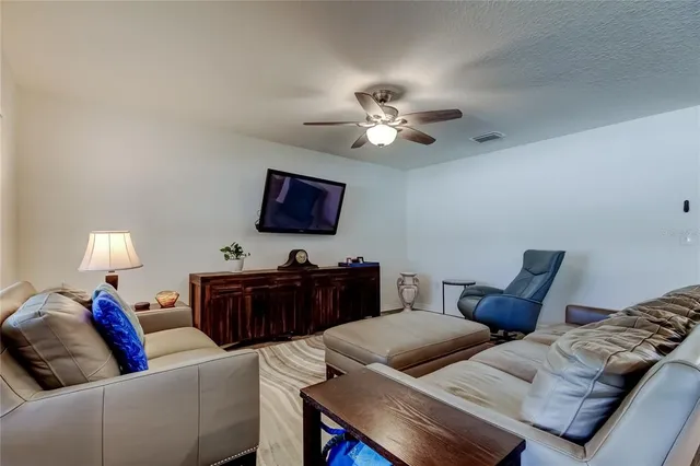 a living room with furniture a ceiling fan and a window