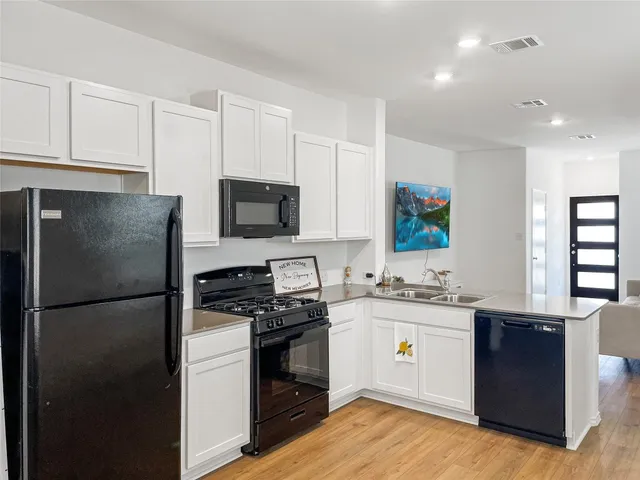 a kitchen with stainless steel appliances granite countertop a sink a stove and a refrigerator with wooden cabinets