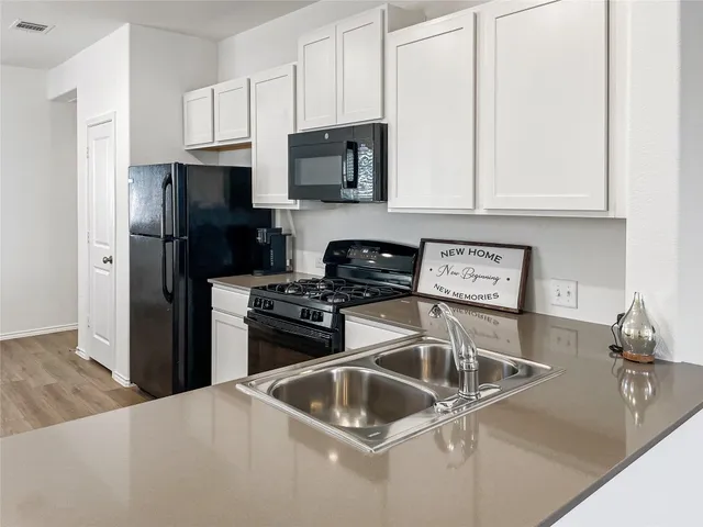 a kitchen with stainless steel appliances granite countertop a refrigerator stove top oven and sink