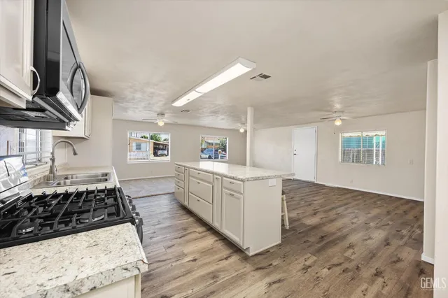a kitchen with sink stove and cabinets
