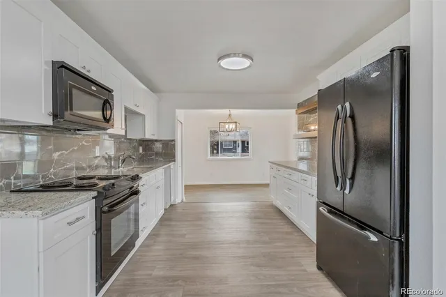 a kitchen with stainless steel appliances granite countertop a refrigerator and a stove