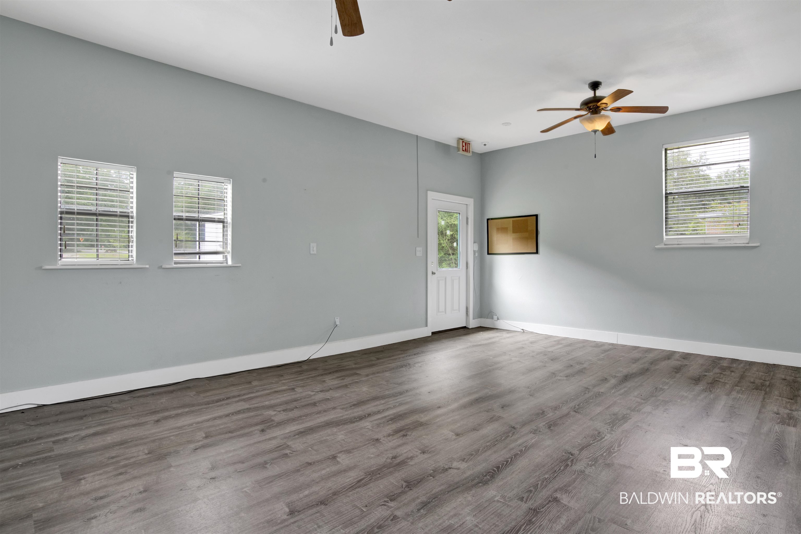 17714 Horseneck Road Bay Minette, AL 36507 - Photo 11 of 36 Spacious room featuring wood-finish flooring, two ceiling fans, and multiple windows with blinds