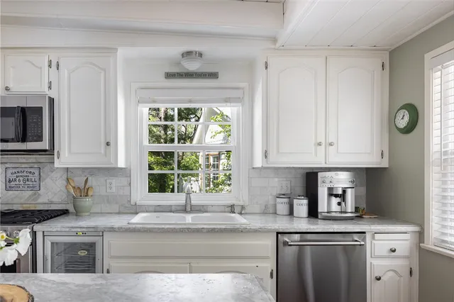 a kitchen with stainless steel appliances granite countertop a sink a stove a microwave a refrigerator and cabinets