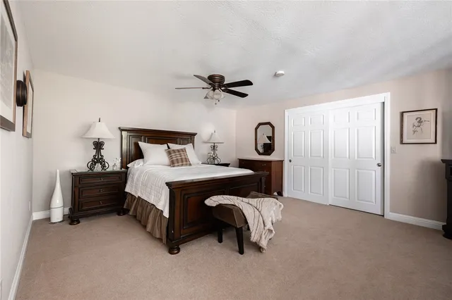 a bed room with a bed and a ceiling fan