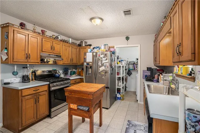 a view of kitchen with stainless steel appliances granite countertop lots of counter top space