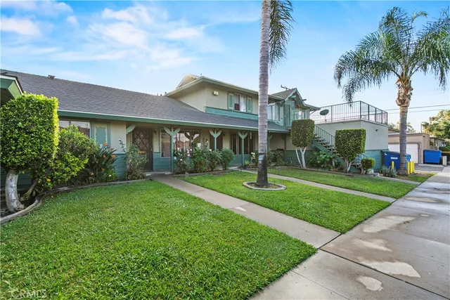 a front view of a house with a yard and potted plants